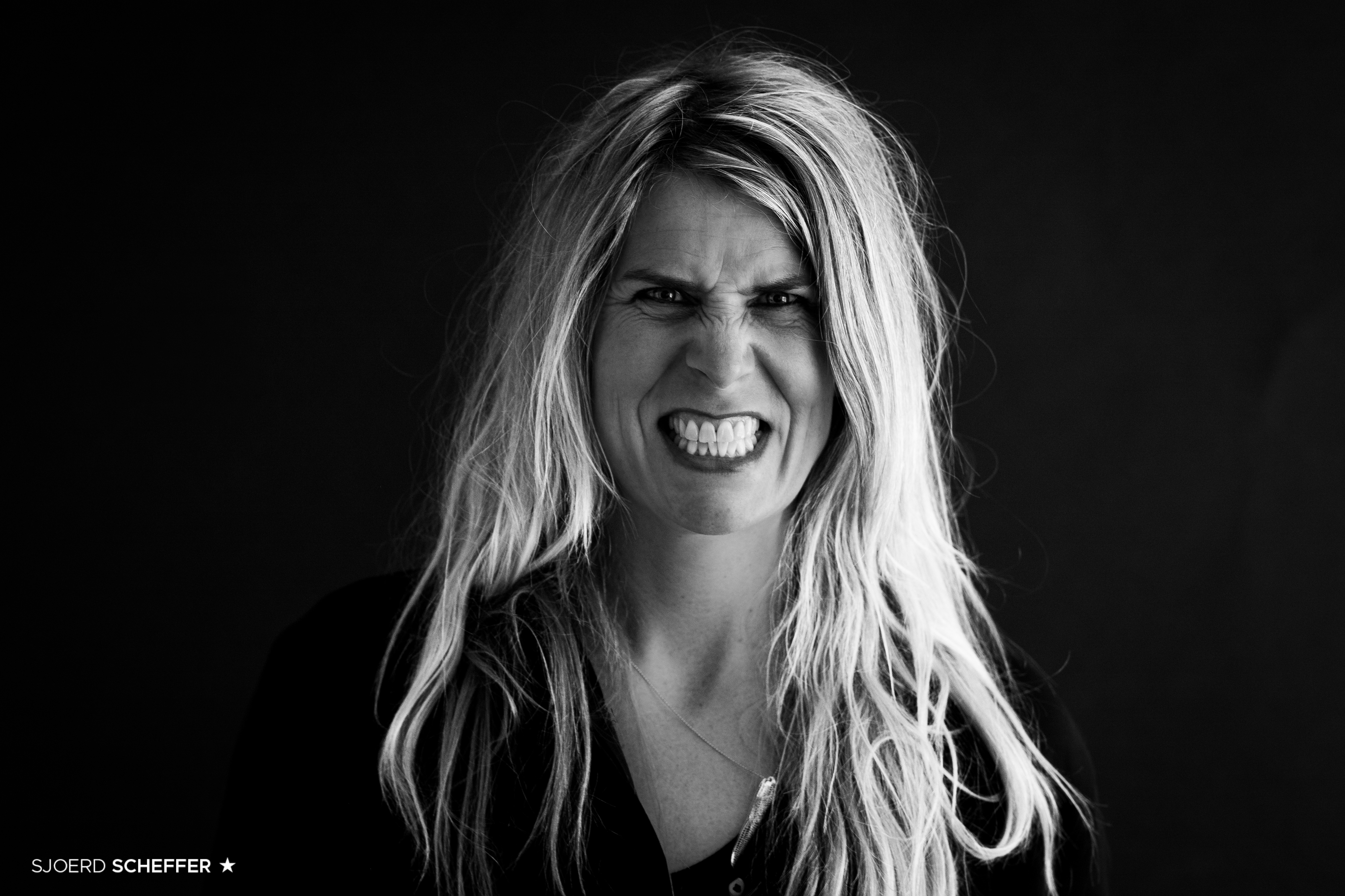 Portret van Kim Padding in zwart-wit, wilde haren, directe blik, tanden bloot — foto Sjoerd Scheffer